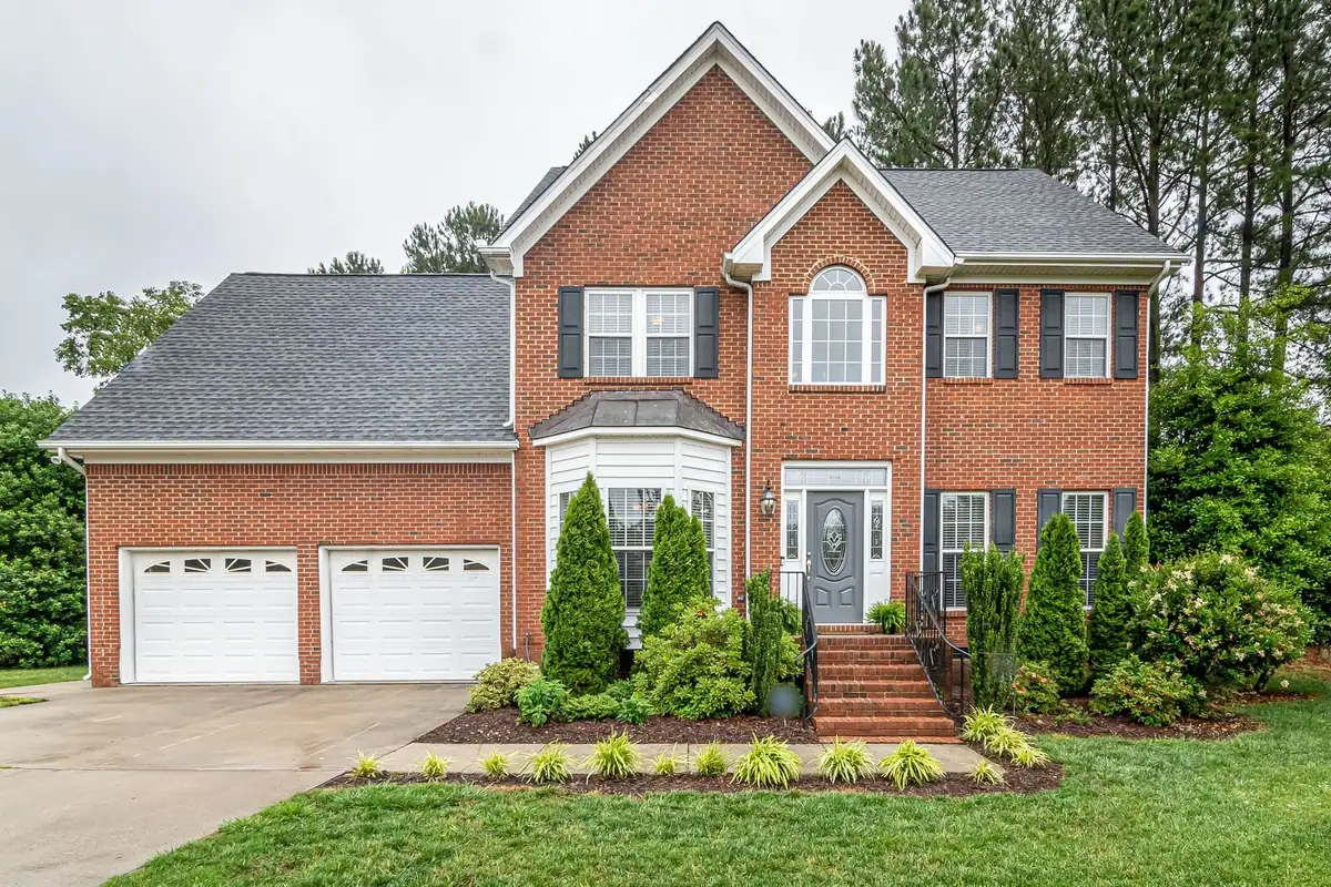 Brick home with layered foundation plantings, evergreens and a mulched front bed