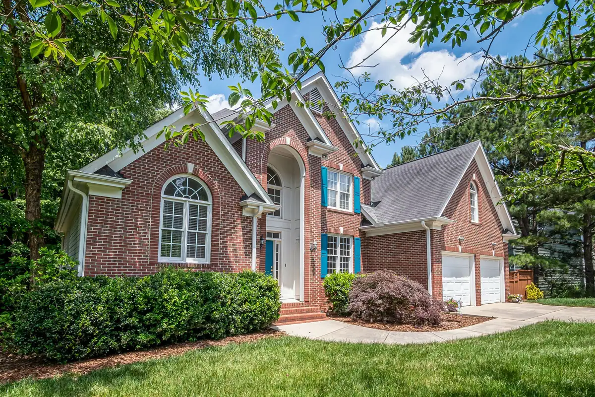 Brick home with neatly clipped hedges and a mulched front bed