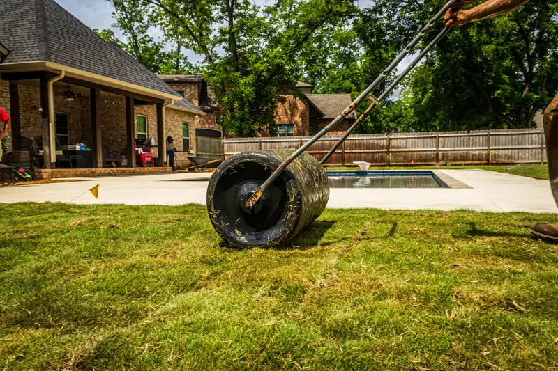 Lawn roller pressing down newly laid sod in a backyard