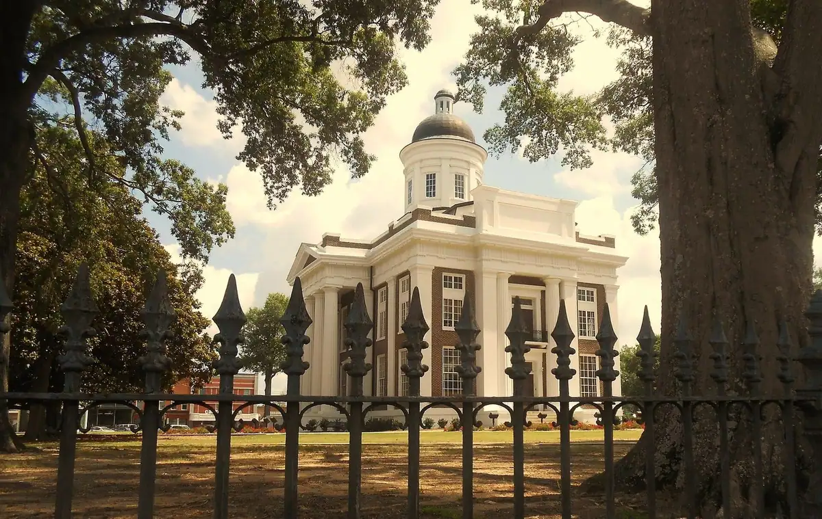 The old Madison County Courthouse on the square in Canton, Mississippi, framed by oak trees