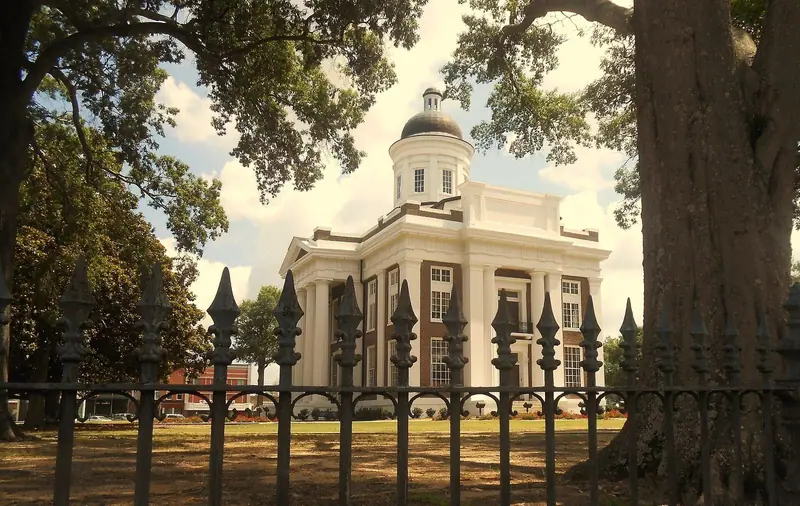 The old Madison County Courthouse on the square in Canton, Mississippi, framed by oak trees