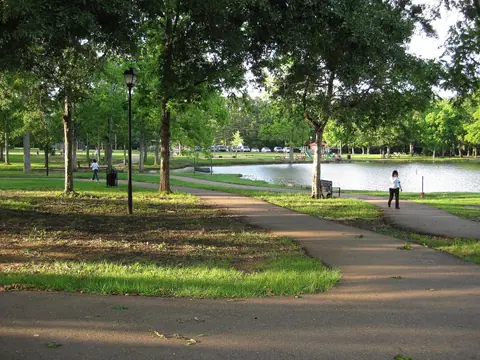 Walking path under shade trees beside the pond at Strawberry Patch Park in Madison, Mississippi